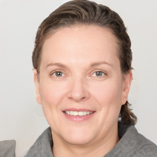 Joyful white adult female with medium  brown hair and grey eyes