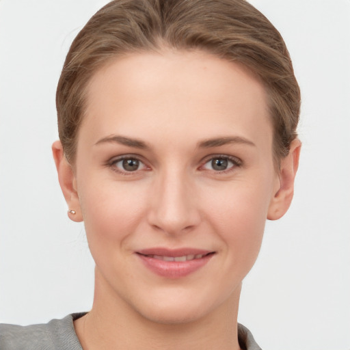 Joyful white young-adult female with short  brown hair and grey eyes