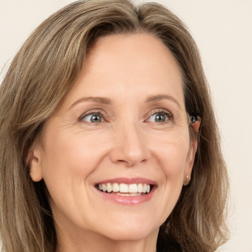 Joyful white adult female with long  brown hair and green eyes