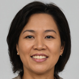 Joyful asian adult female with medium  brown hair and brown eyes