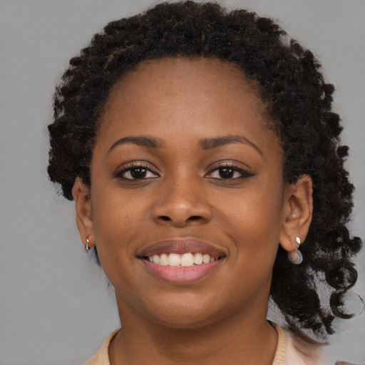 Joyful black young-adult female with long  brown hair and brown eyes