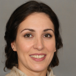 Joyful white adult female with medium  brown hair and brown eyes