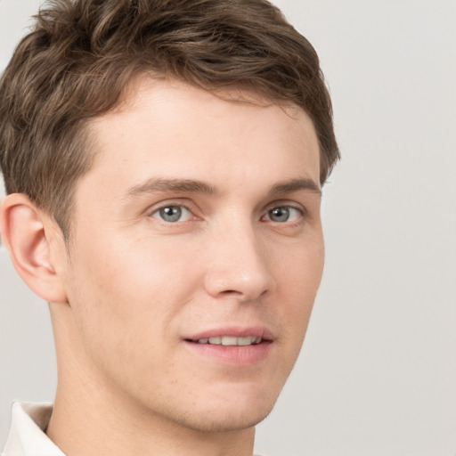 Joyful white young-adult male with short  brown hair and grey eyes