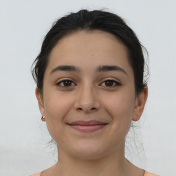 Joyful latino young-adult female with medium  brown hair and brown eyes