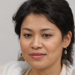 Joyful latino adult female with medium  brown hair and brown eyes