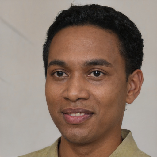 Joyful black young-adult male with short  black hair and brown eyes