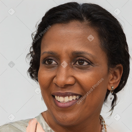 Joyful black adult female with medium  brown hair and brown eyes