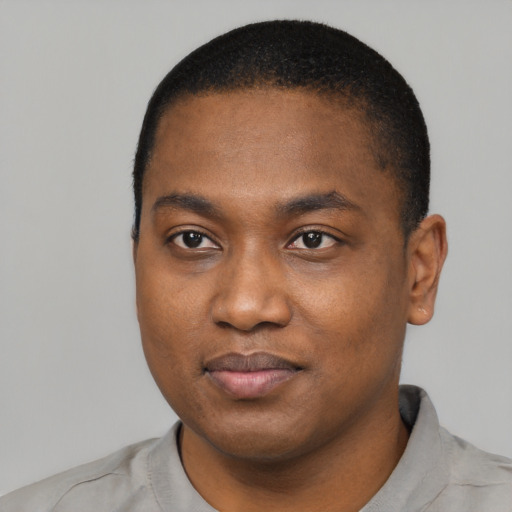 Joyful black young-adult male with short  black hair and brown eyes