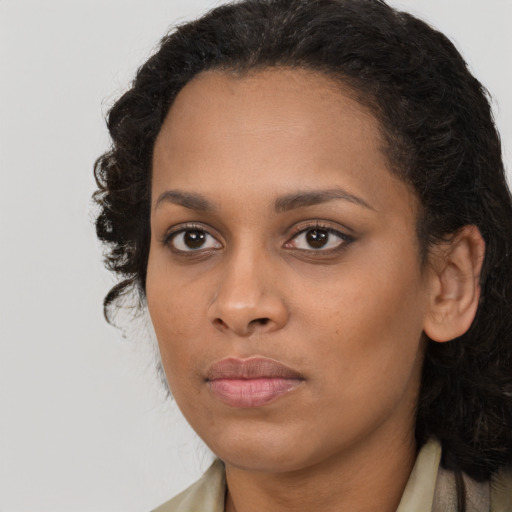 Joyful black young-adult female with long  brown hair and brown eyes