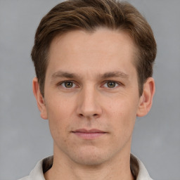 Joyful white young-adult male with short  brown hair and grey eyes