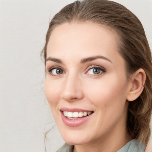 Joyful white young-adult female with medium  brown hair and grey eyes