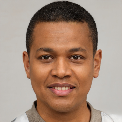 Joyful black young-adult male with short  black hair and brown eyes
