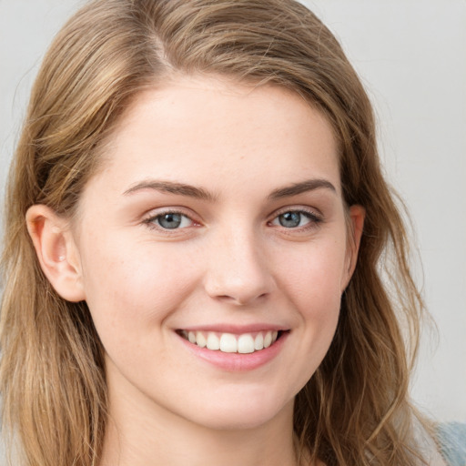 Joyful white young-adult female with long  brown hair and blue eyes