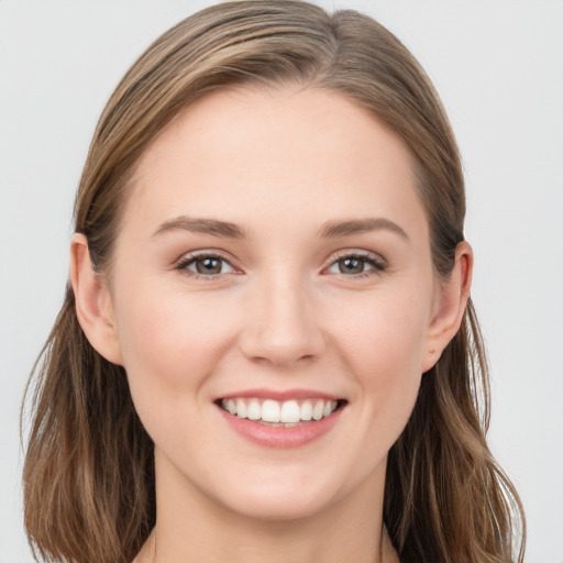 Joyful white young-adult female with long  brown hair and grey eyes