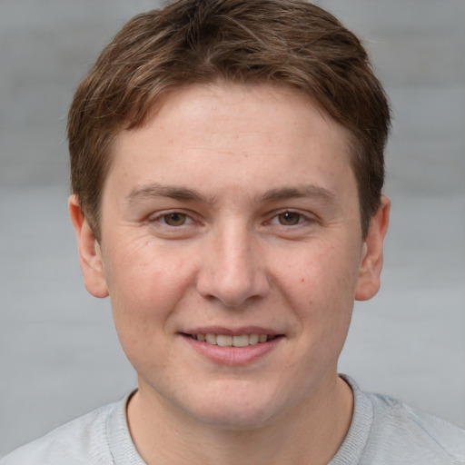 Joyful white young-adult male with short  brown hair and grey eyes