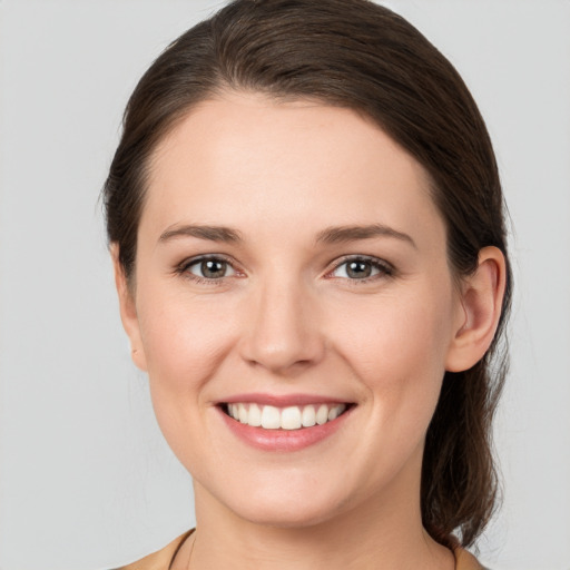 Joyful white young-adult female with medium  brown hair and grey eyes