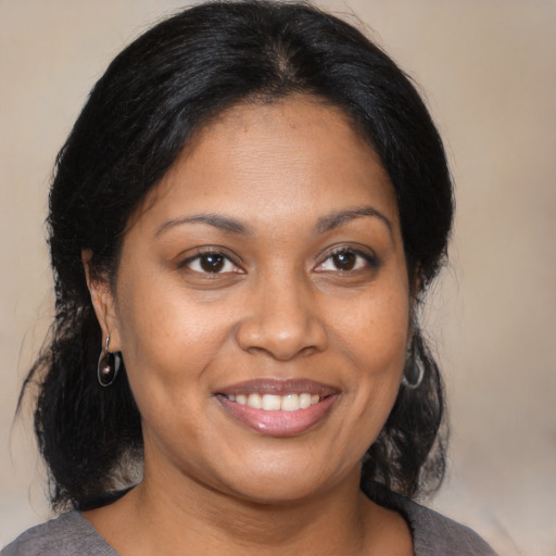 Joyful black young-adult female with medium  brown hair and brown eyes