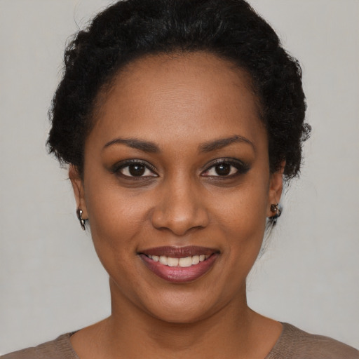 Joyful black young-adult female with short  brown hair and brown eyes