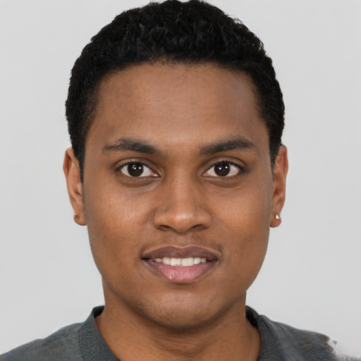Joyful black young-adult male with short  black hair and brown eyes