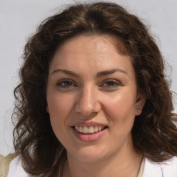 Joyful white adult female with medium  brown hair and brown eyes