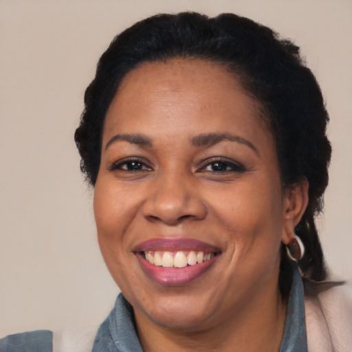 Joyful black adult female with medium  black hair and brown eyes