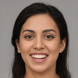 Joyful latino young-adult female with long  brown hair and brown eyes