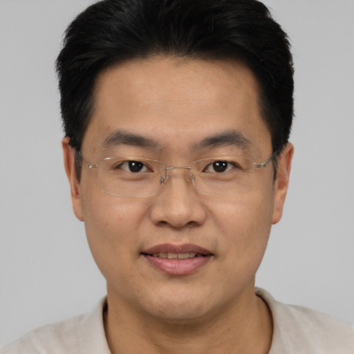 Joyful asian adult male with short  black hair and brown eyes
