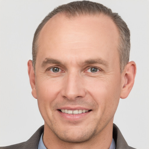 Joyful white adult male with short  brown hair and grey eyes