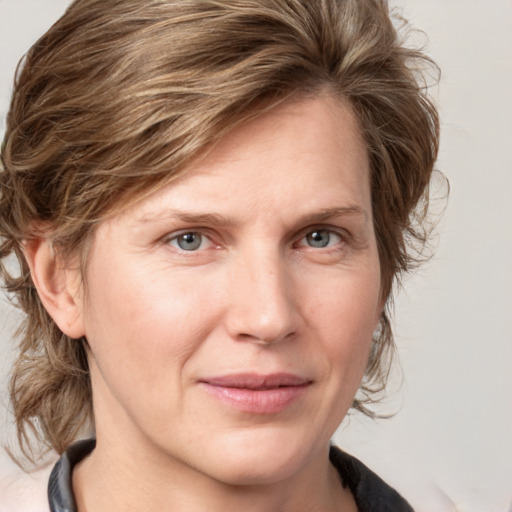 Joyful white adult female with medium  brown hair and grey eyes