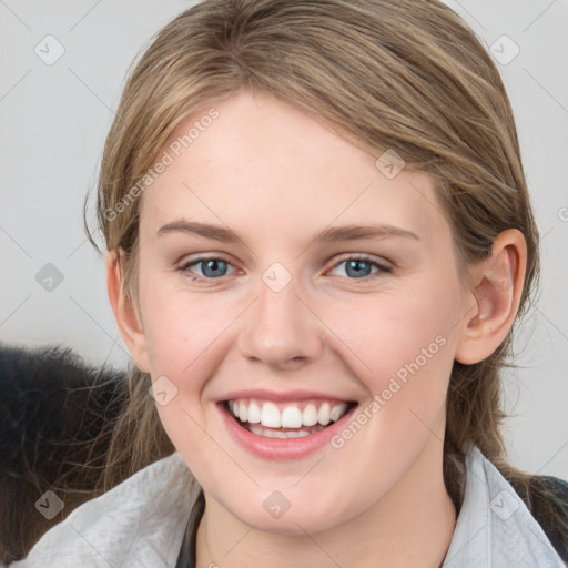 Joyful white young-adult female with medium  brown hair and blue eyes