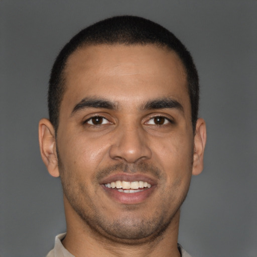 Joyful latino young-adult male with short  brown hair and brown eyes