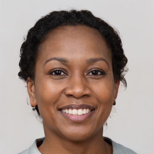 Joyful black adult female with short  brown hair and brown eyes