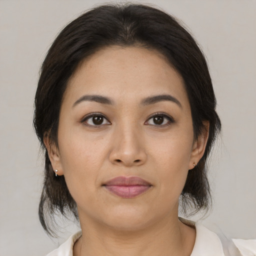 Joyful latino young-adult female with medium  brown hair and brown eyes