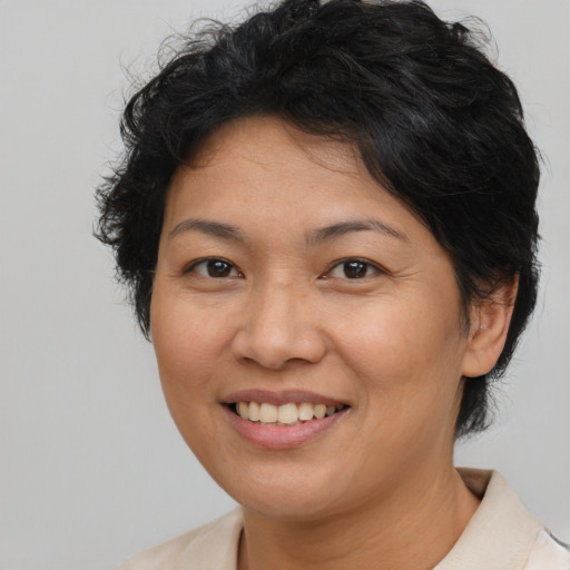 Joyful latino adult female with medium  brown hair and brown eyes