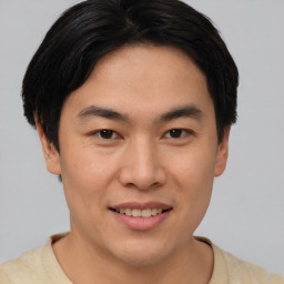 Joyful asian young-adult male with short  brown hair and brown eyes