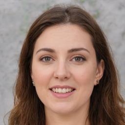 Joyful white young-adult female with long  brown hair and green eyes