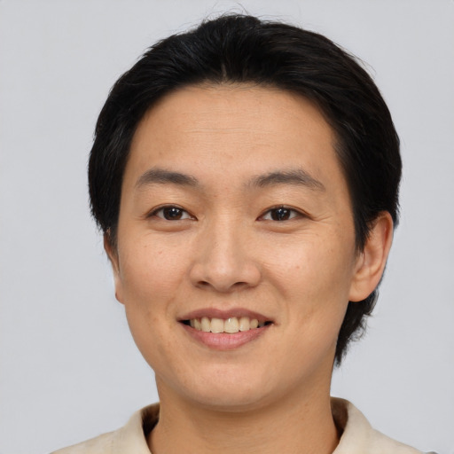 Joyful asian adult female with short  black hair and brown eyes
