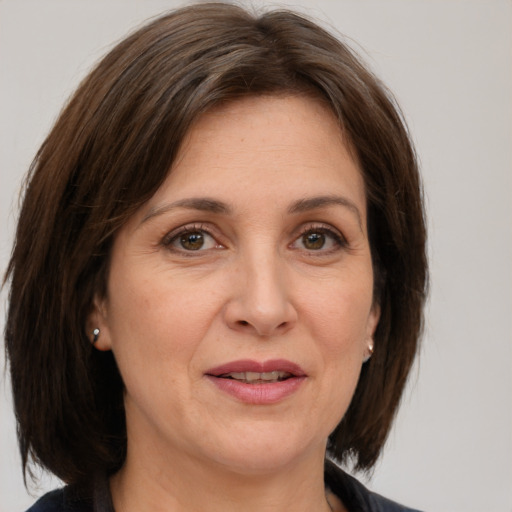 Joyful white adult female with medium  brown hair and grey eyes