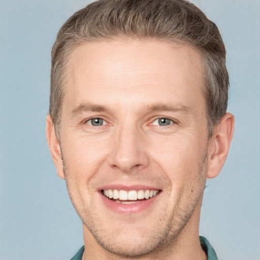 Joyful white adult male with short  brown hair and grey eyes