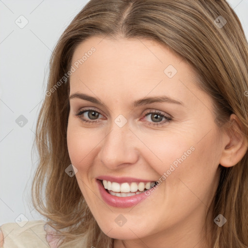 Joyful white young-adult female with long  brown hair and brown eyes