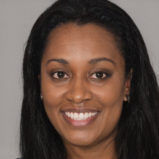 Joyful black young-adult female with long  black hair and brown eyes