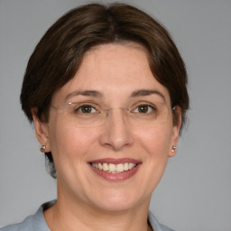 Joyful white adult female with medium  brown hair and blue eyes