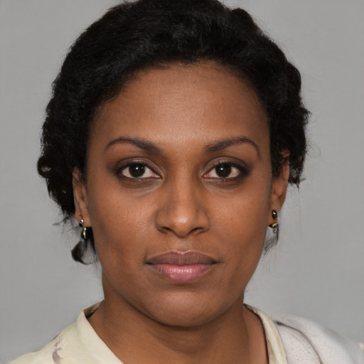 Joyful black young-adult female with short  brown hair and brown eyes