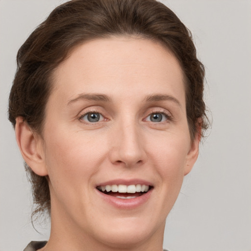 Joyful white young-adult female with short  brown hair and grey eyes