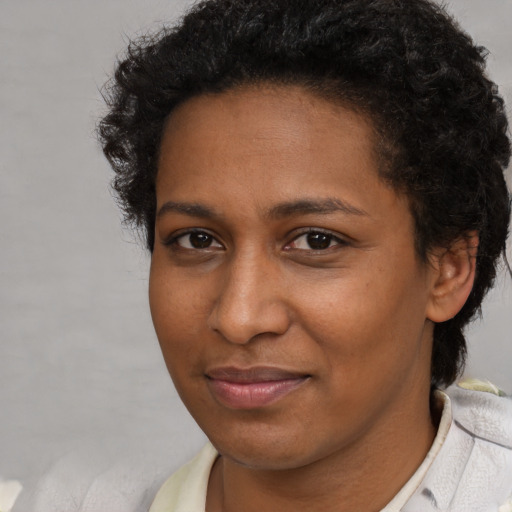 Joyful black young-adult female with short  brown hair and brown eyes