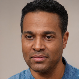 Joyful latino adult male with short  black hair and brown eyes