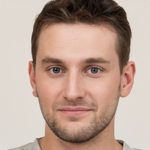 Joyful white young-adult male with short  brown hair and grey eyes