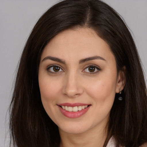 Joyful white young-adult female with long  brown hair and brown eyes