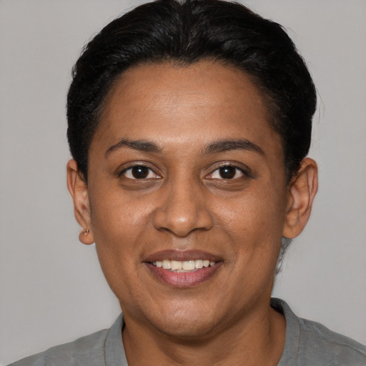Joyful black adult female with short  black hair and brown eyes