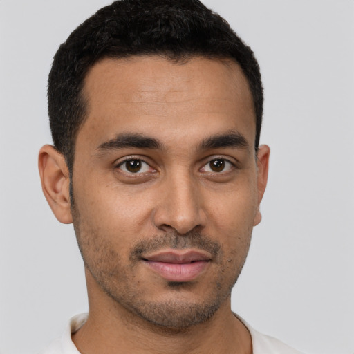 Joyful latino young-adult male with short  brown hair and brown eyes